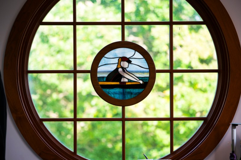 A circular stainless glass window displaying a rower.