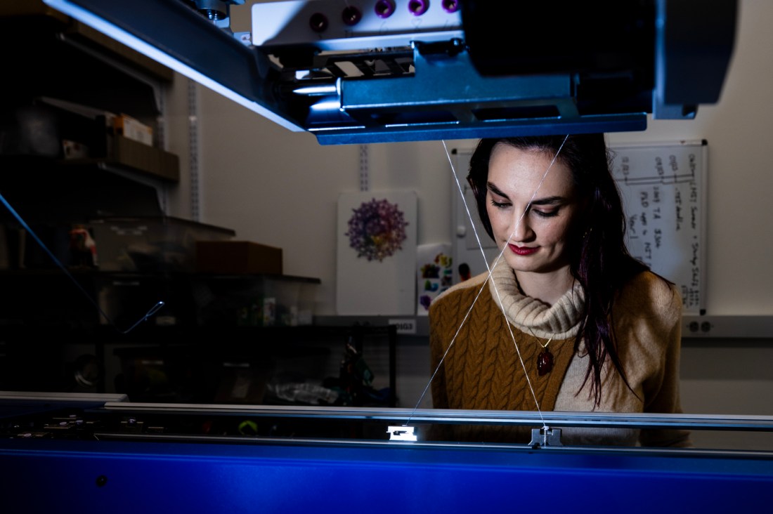 Megan Hoffman working at an automatic knitting machine.