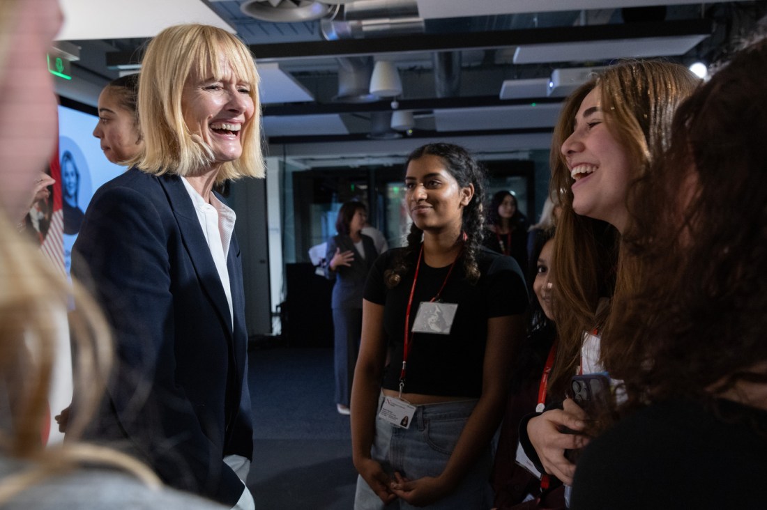 Attendees smile and interact at an event in London.