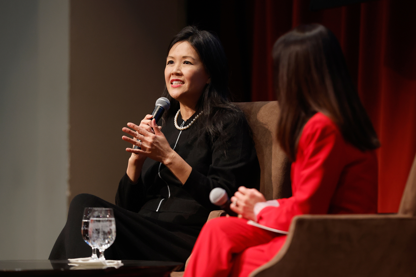 Dr. Rita Ng speaking into a microphone in a lecture hall on the Oakland campus.