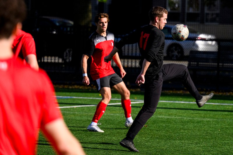 A player wearing all black trapping the ball on their knee.