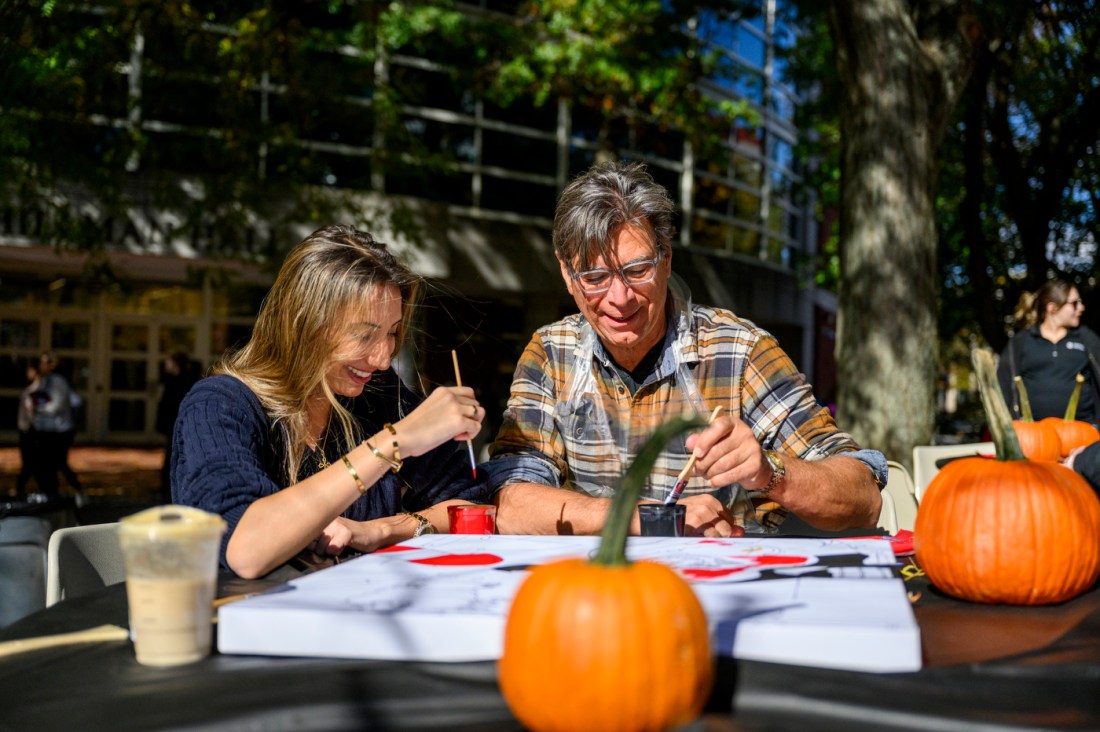 A student and their parent painting on the Boston campus. 