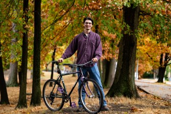 Sam Whitby posing with his bicycle.