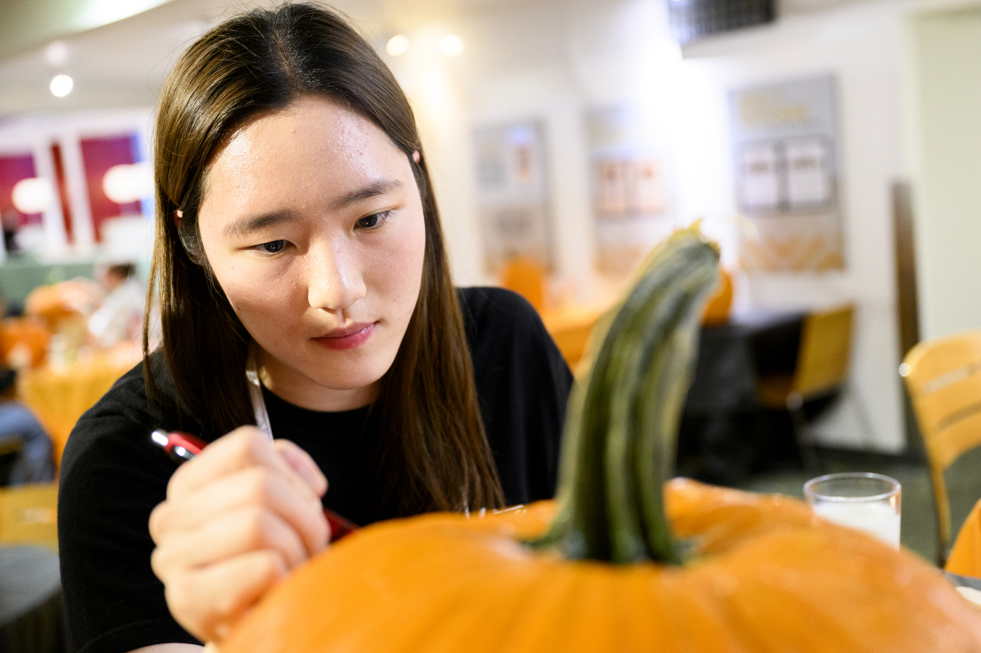 A person carving a pumpkin.