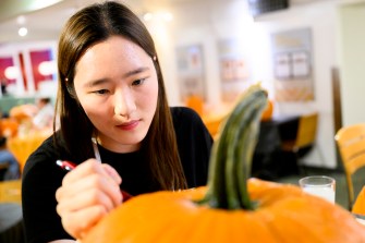 A person carving a pumpkin.