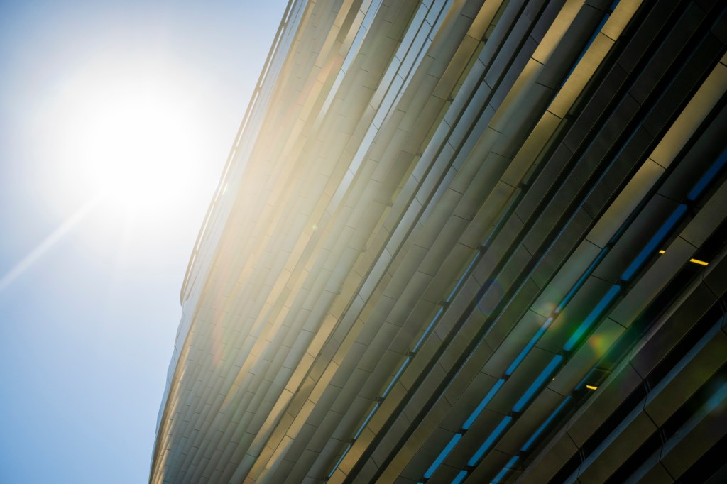 The sun shining outside of the EXP building on the Boston campus.