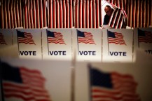 Polling booths are covered with prints of the American flag featuring the word 'VOTE' in blue.