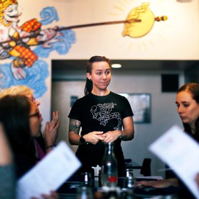 A server at a restaurant standing in front of a table of people holding menus.