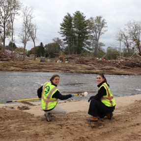 Two people wearing neon vests next to a river in North Carolina.