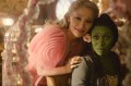 A screen capture from the Wicked movie showing Glinda leaning over Elphabra with a hand on her shoulder.