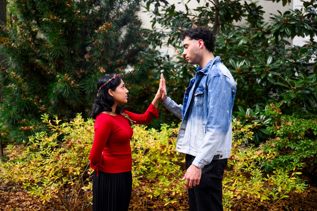 Two members of the Shakespeare society with one hand pressed to each other.