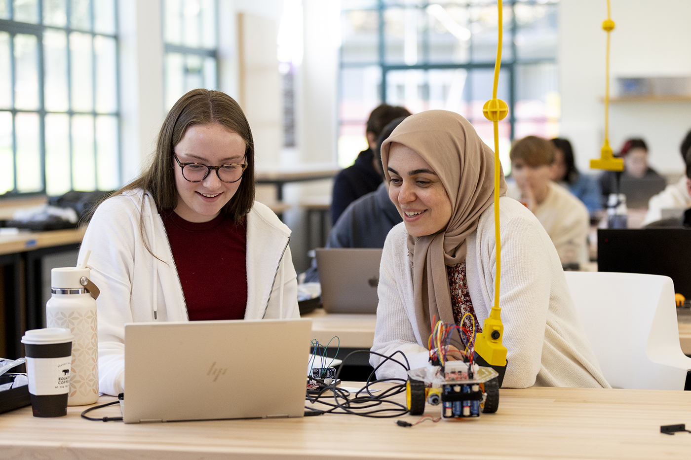 Two people working together in a modern classroom.