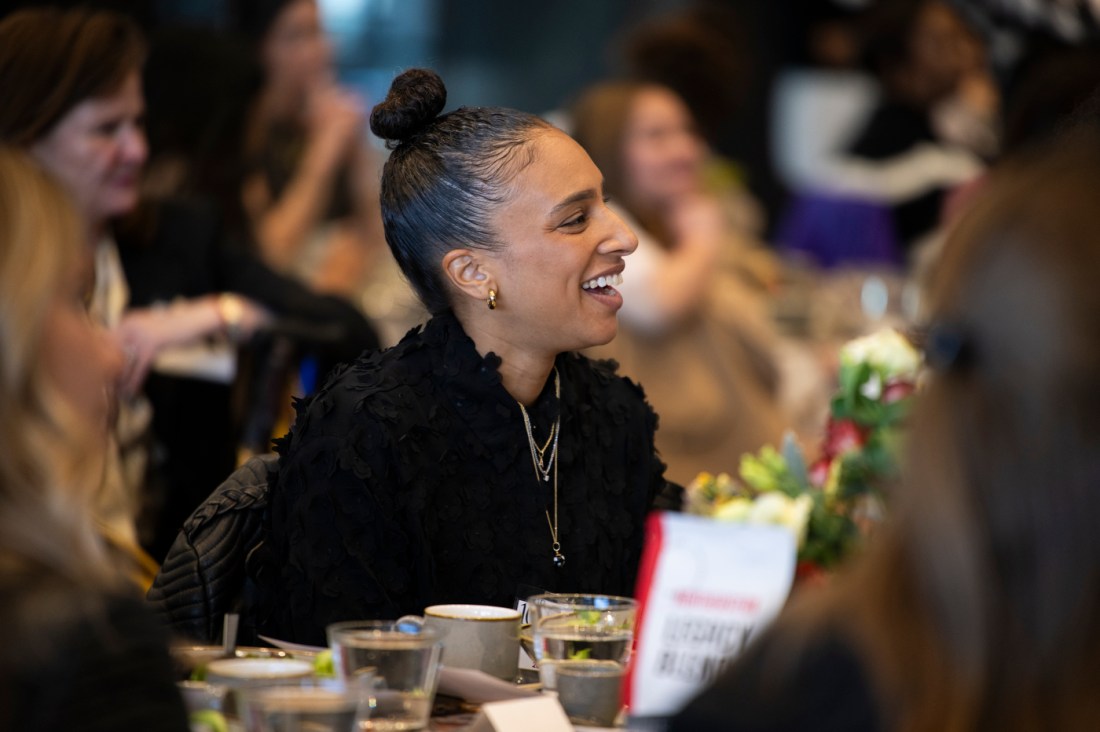 An audience member laughing at a luncheon.