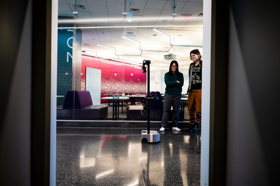 Emily Taylor and Althea Masetti Zanini watching a robot named Marlo.