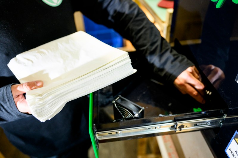 Hands assembling or operating a machine in a workshop.