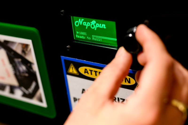 Close-up of a person using a machine in a workshop setting.