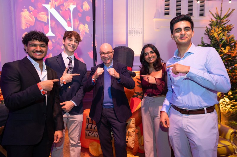 President Joseph E. Aoun poses with students and faculty during Northeastern’s Thanksgiving dinner at Lindley Hall in London.