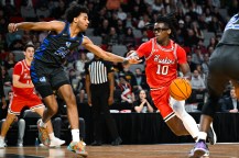 Harold Woods of Northeastern moves past a defender during a basketball game.