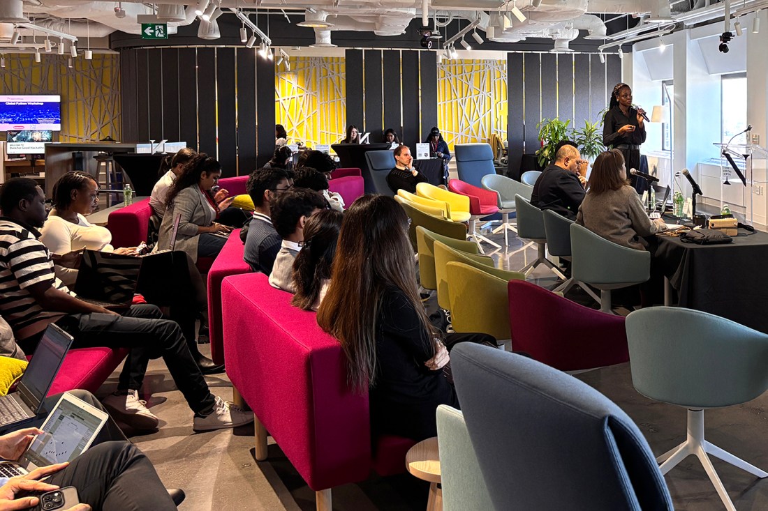 A room full of students sitting on couches while one student presents. 