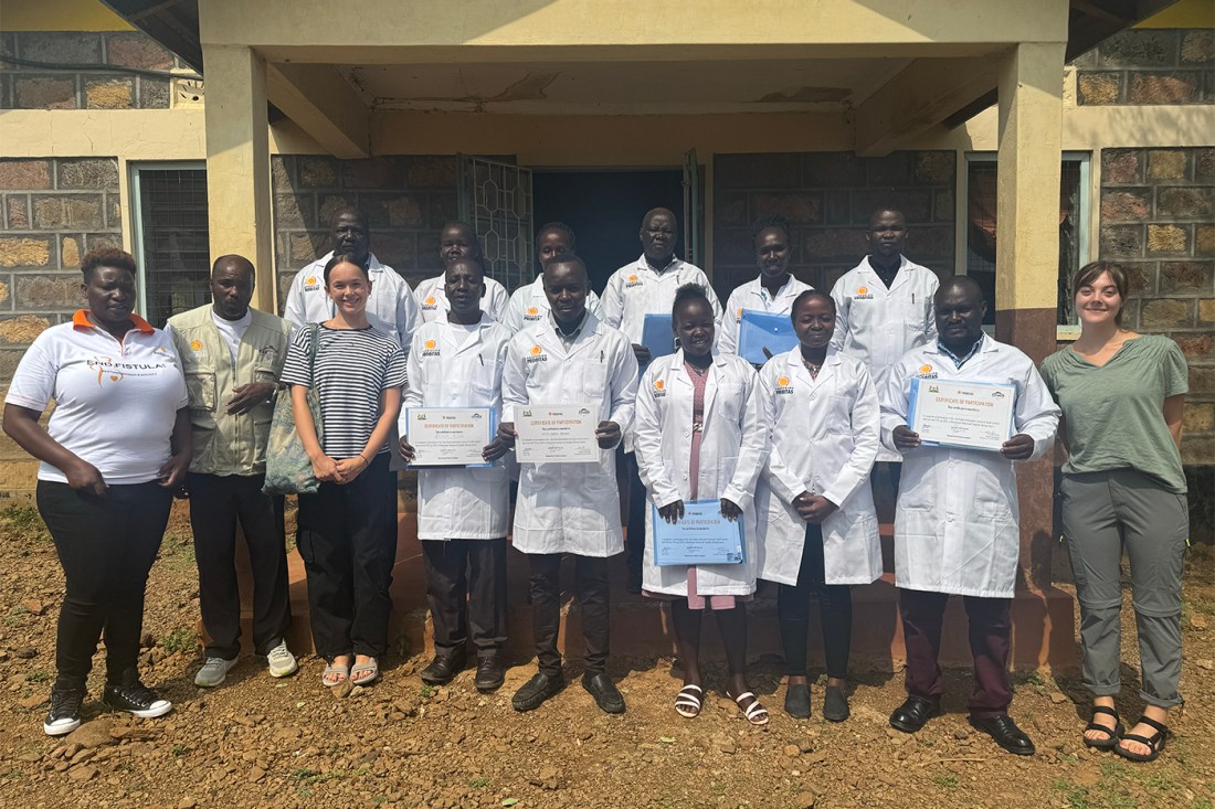 A group of people posing together, some wearing white medical coats.