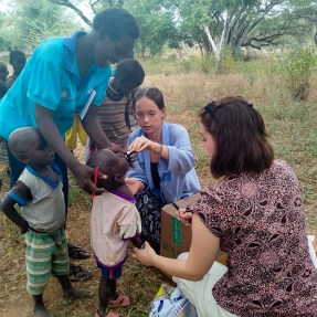 Two students working with people in Kenya.