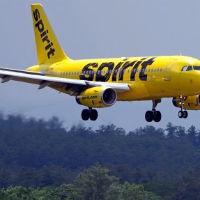 A yellow Spirit Airlines plane flying in for landing.