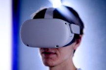 A person wearing a virtual reality headset in a softly lit environment.