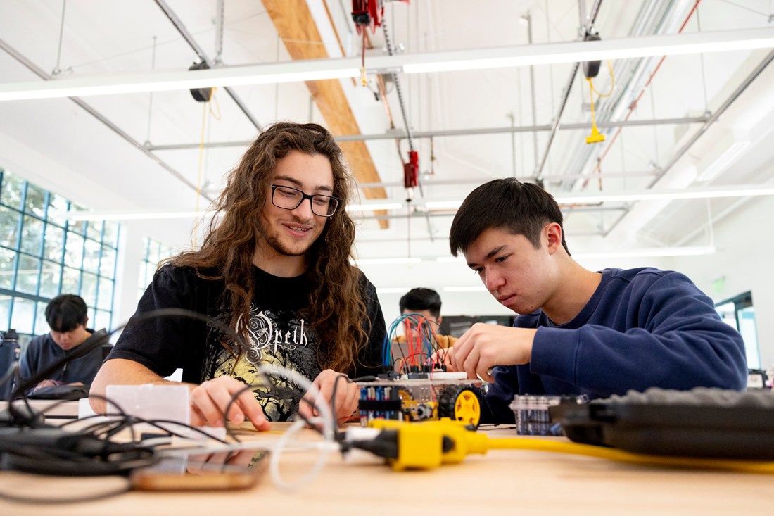 Two students working on a robot together.