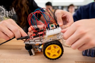 Two students working on a robot together.