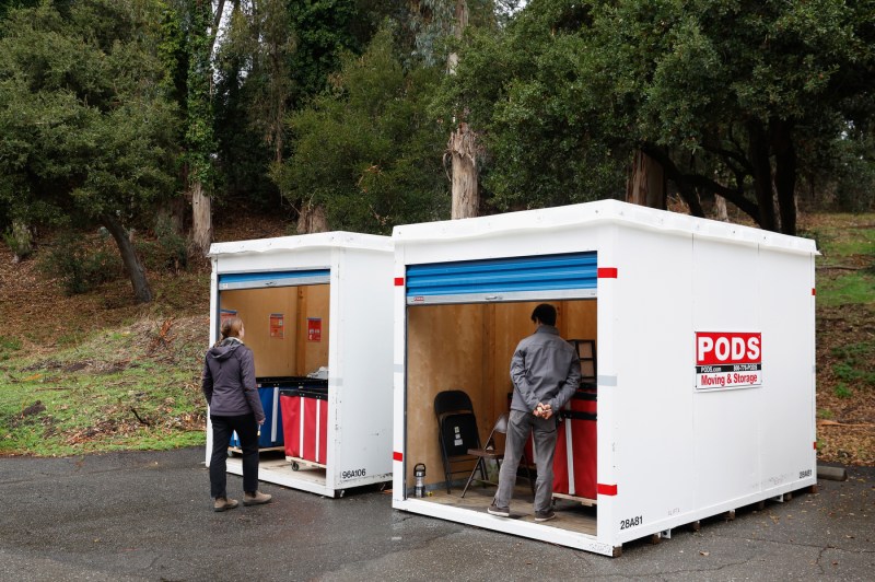 Students standing in white Pods storage containers.