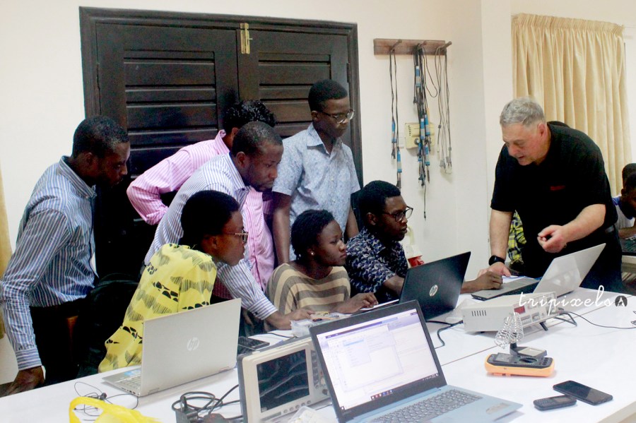 A group of people sitting around laptops in Ghana.