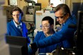 Alexander Ivanov, Anne-Lise Marie, and Yunnan Gao all standing around a laptop looking at the screen.