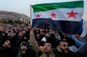 Syrian citizens waving the revolutionary flag.