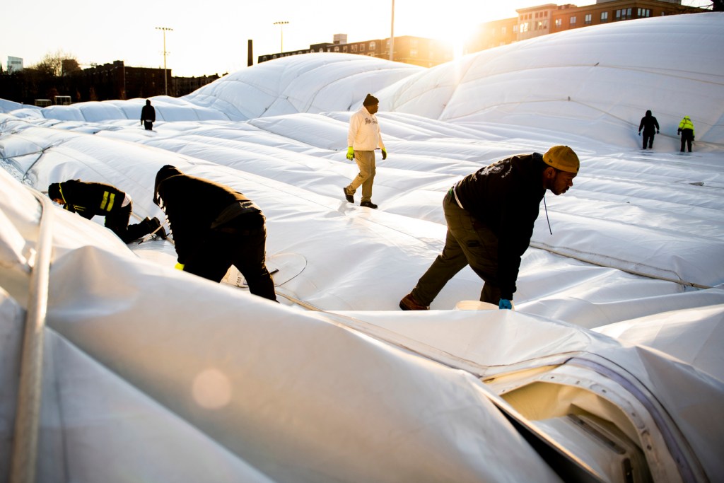 Facilities workers helping remove the Carter Playground bubble dome.