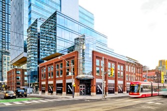 Urban building with modern glass architecture, located at a busy city intersection.