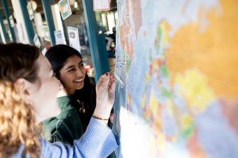 Two people smile as they interact with a map during a group activity.