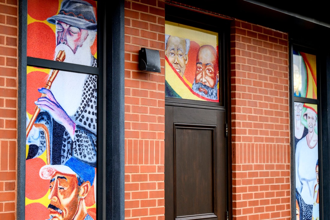 A brick building with windows painted with murals.