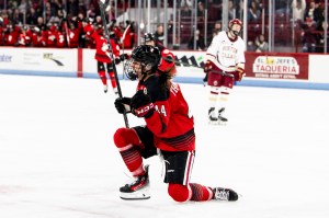 A Northeastern hockey player celebrates after scoring a goal.