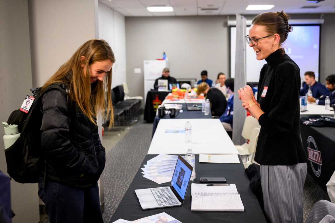 Two people talking at the athletics co-op fair.