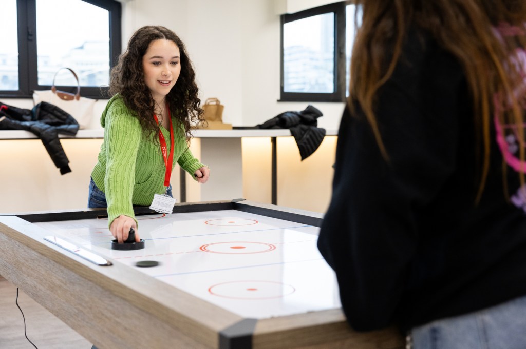 A person plays an air hockey game indoors.