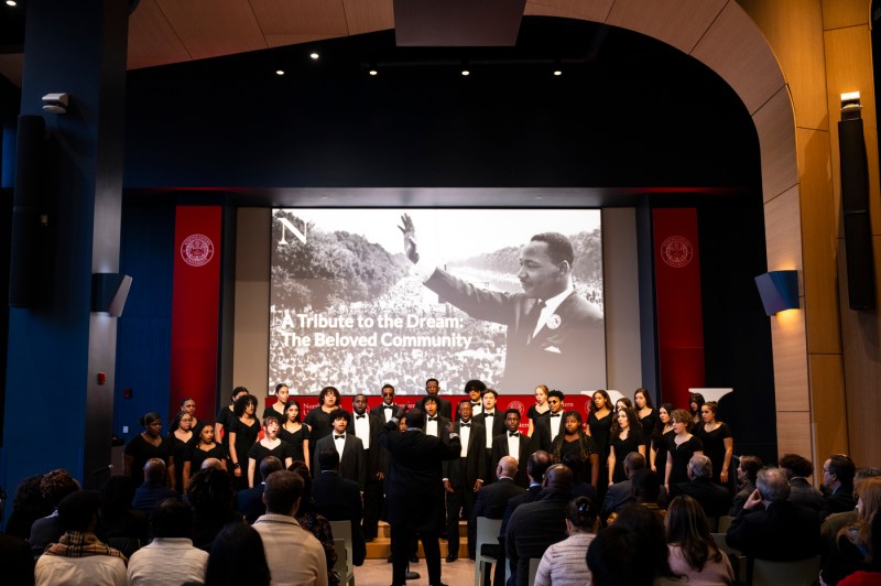 A choir performs on stage during an event in a large auditorium.