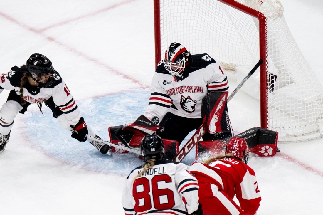 Northeastern womens hockey goalie saving a BU shot.