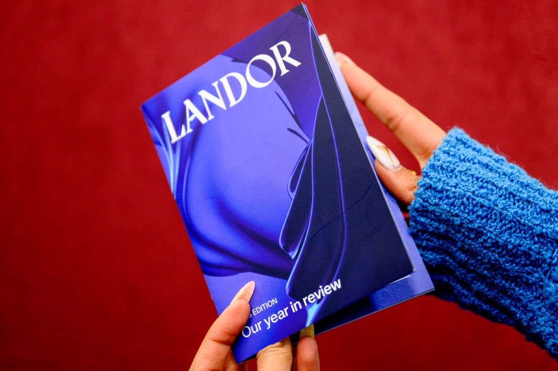 Yana Puri's hands holding a 'Landor' pamphlet to show it's cover.