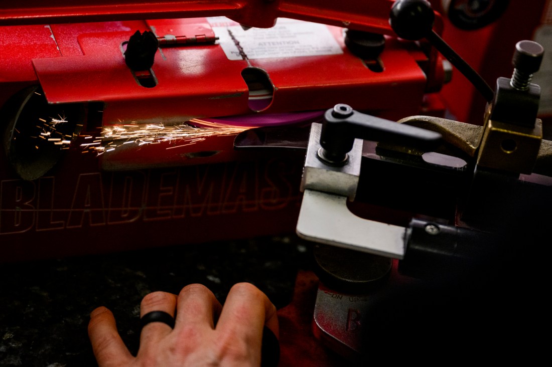 A hockey sharpening tool sending sparks off of a blade.