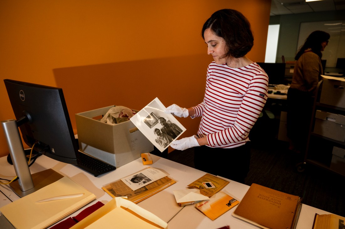 Irene Gates holding up an archival photograph.