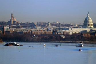 The view of a river in DC from a bridge where search and rescue crews are in boats on the water.