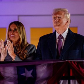 Melania and Donald Trump standing next to each other, Melania clapping her hands together.