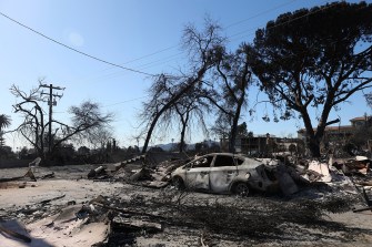 A charred car and house in Los Angeles.