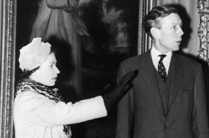 A black and white photo of a young Queen Elizabeth II standing next to Anthony Blunt, a man wearing a suit and tie.