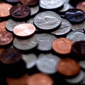 Stacks of US coins, including pennies, quarters, and nickels.